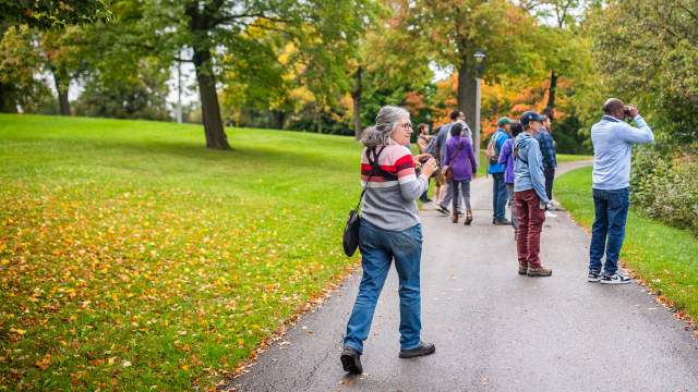 a woman with binoculars birding in a park