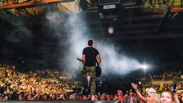 Guitarist on Stage with Arena Crowd | Raising Cane's River Center