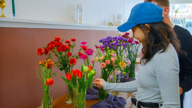 a couple looking at vases of flowers