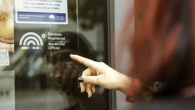 Someone pointing at the Rainbow registered logo on a window.