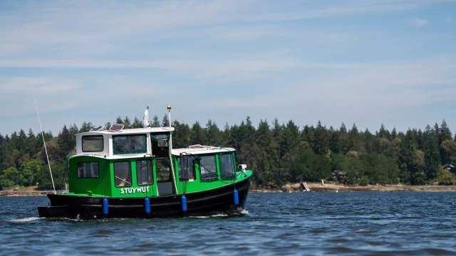 A small green ferry on water.
