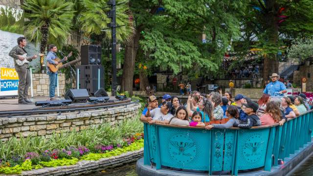 River barge floating by with people and man singing at Arneson River Theatre