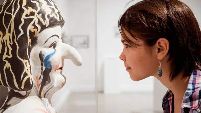 A girl looking at a statue.