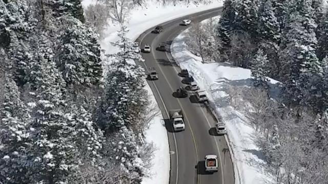 Cars driving on a slightly wet road in a snowy canyon