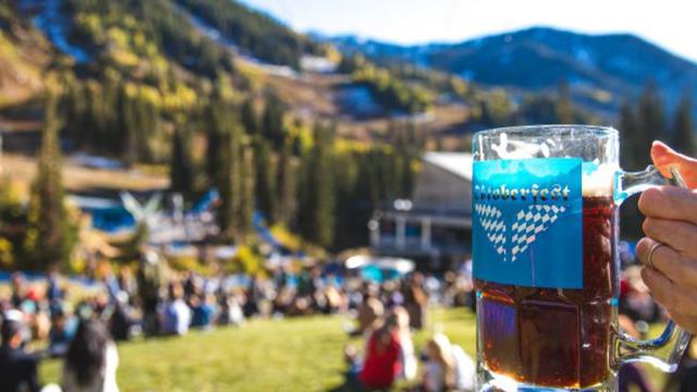 A person holding up a stein at Oktoberfest at Snowbird.
