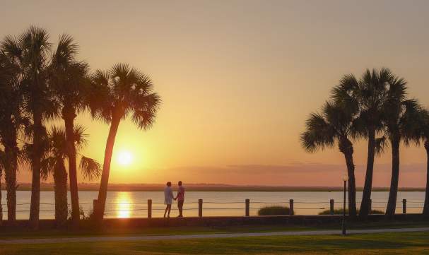 A couple enjoys the sunset along the Jekyll River in the Jekyll Island Historic District