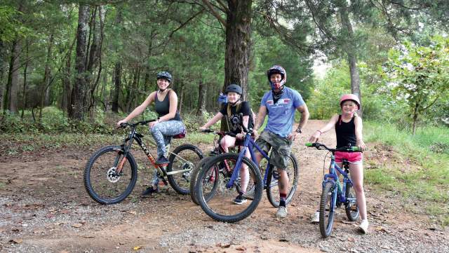 family on bikes in wooded trail