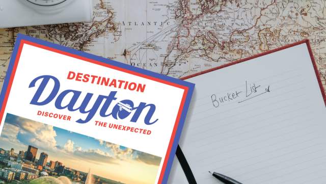 a graphic showing the Destination Dayton Visitors Guide, along with a map, camera, sunglasses and "to do" list