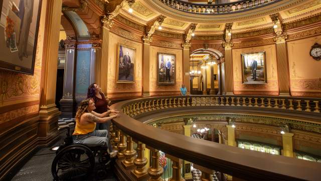 Two people looking around the rotonda at the Michigan State Capitol building