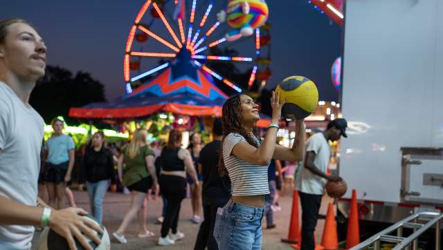 People throwing basketballs at one of the games at the Ingham County Fair
