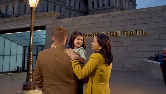 Family standing in front of Heritage Hall