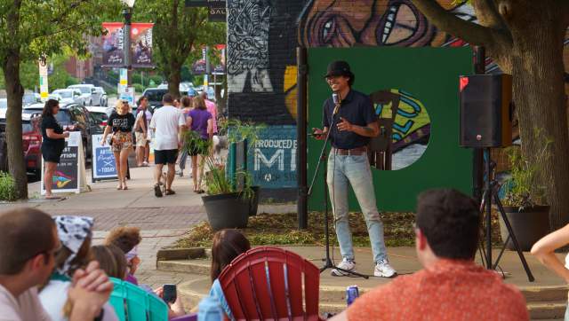 Person standing at a mic while others listen