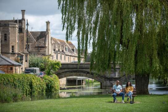 Two people sat on park bench in Stamford town centre