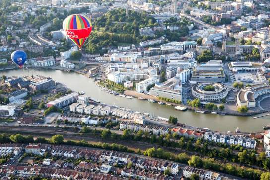 An aerial view of hot air balloons flying over Bristol Harbourside