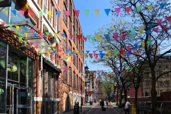 Canal Street in Manchester with coloured bunting on a sunny day