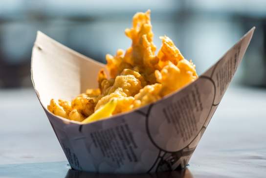 A portion of fish and chips, served in a carton that looks somewhat boat-shaped