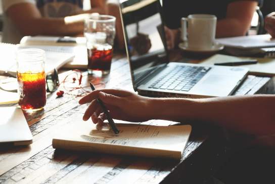 Photograph of a group of people working around a desk
