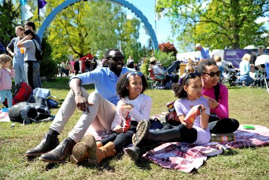 Family sitting in the grass at the Cheltenham Jazz Festival, Imperial Gardens.