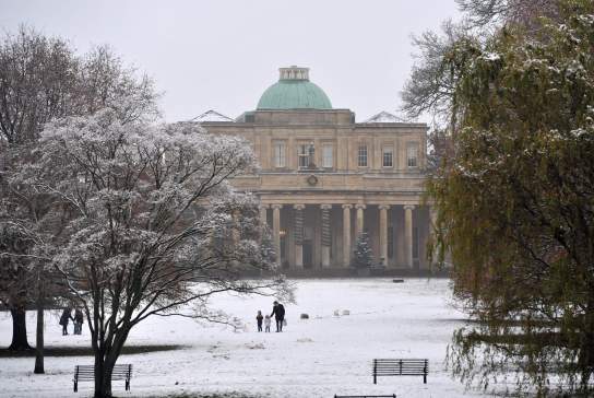 Visitors walking through a snow filled park in Cheltenham, Pittville Park in the snow