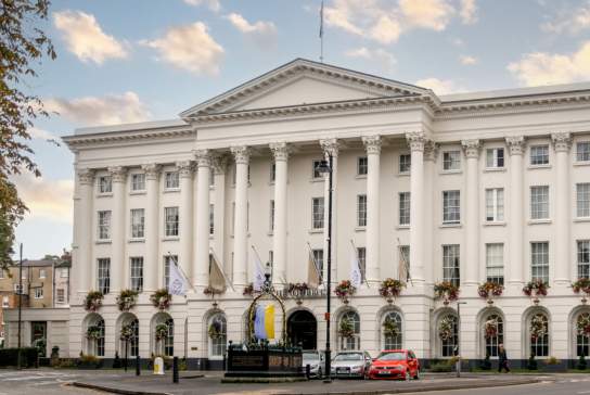 Queens Hotel Cheltenham, view of the exterior of the hotel in the summer with hanging baskets.