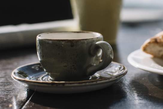 Photograph of a coffee mug and baked item at a cafe