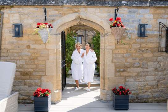 Ladies coming out of spa at Ellenborough Park hotel wearing white robes.