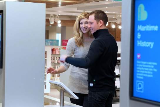 A couple viewing one of the display boards at the Belfast Visitor Centre