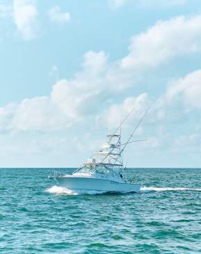 Large white charter boat in turquoise water and bright blue sky