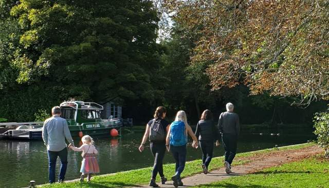People walking along the Thames Path along the river.