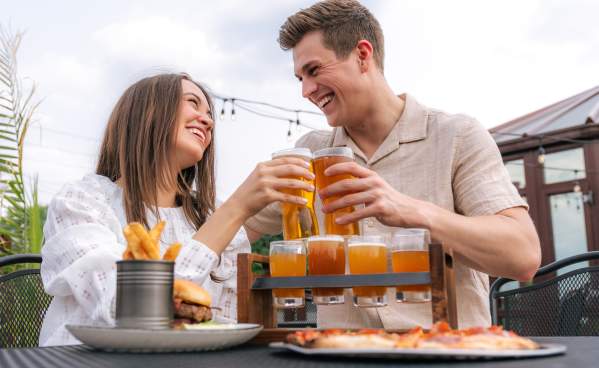 Couple doing a cheers with beer glasses at Grateful Goat.