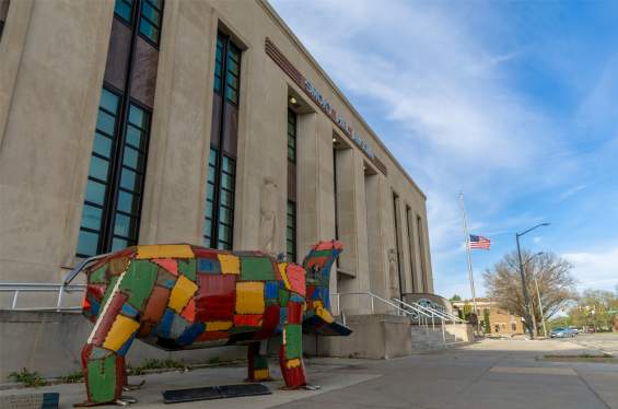a front view of the Smoky Hill Museum with a colorful statue of a hippo titled "Patches" in front