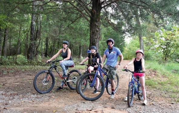 family on bikes in wooded trail