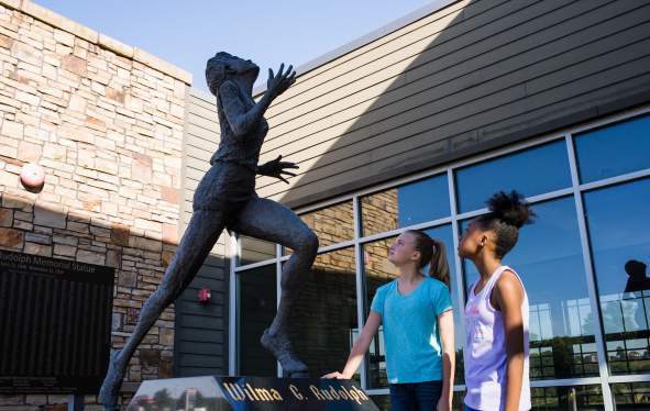 two girls admire the Wilma Rudolph statue