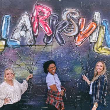 three ladies in front of a balloon Clarksville mural