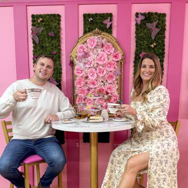couple enjoying tea in a bright pink tearoom