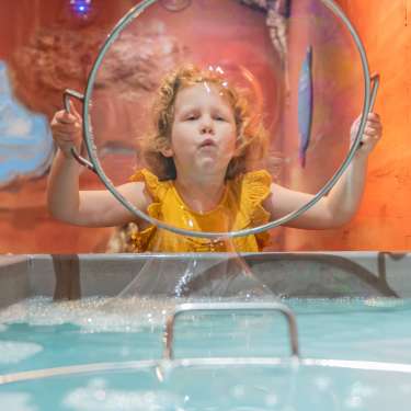 Girl blowing bubble at Customs House Museum