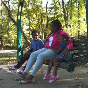 Family sitting on swing on Clarksville Greenway