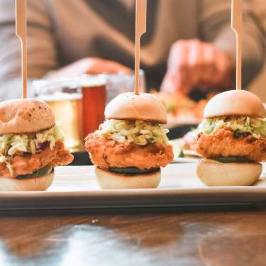 chicken sliders with people eating in the background