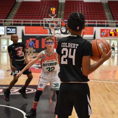 boys playing basketball in a large gym