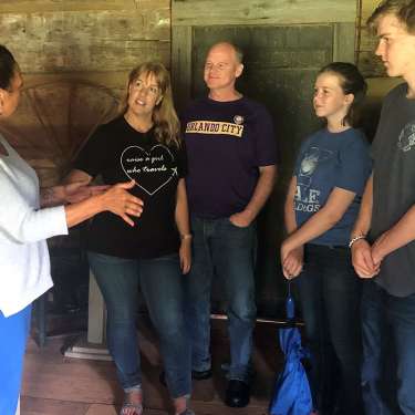 family with a tour guide at a historic cabin