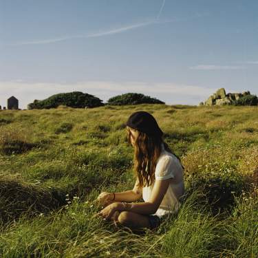 Girl sitting on grass in Autumn