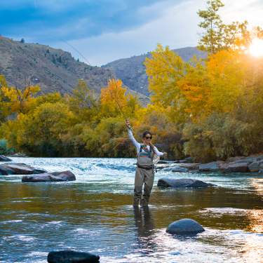 Woman fly fishing in Clear Creek in the Fall in Golden