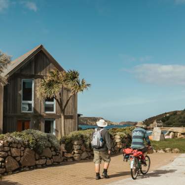 Couple walking past cottages on Tresco