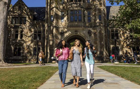 Three college-aged women walking together in U-M Law Quad in Summer