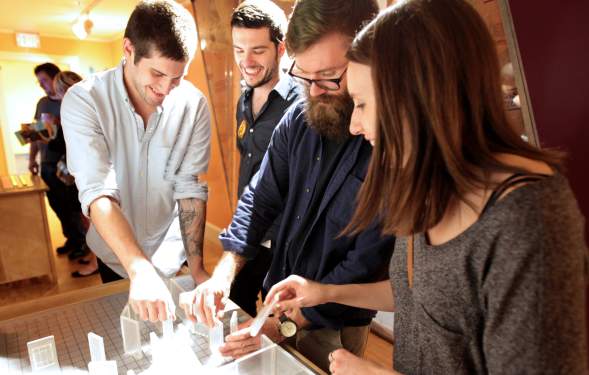 Four adults interacting with a exhibit at the Hands-On Museum