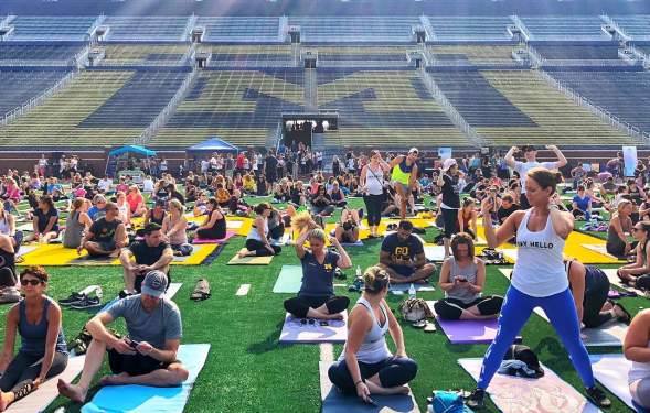 People doing yoga on the football field at Michigan Stadium