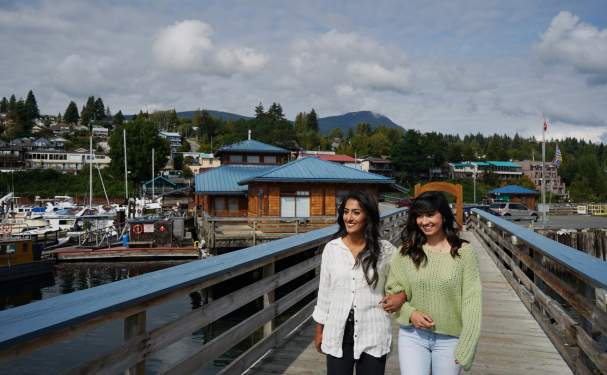 Two woman walk arm-in-arm in Gibsons.