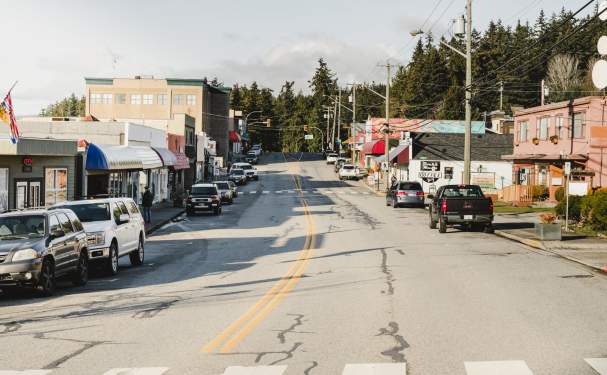 A view of Marine Avenue with vehicles parked in front of local businesses.
