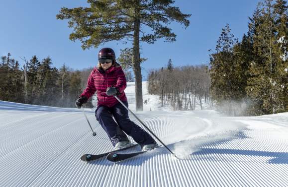 Skier at Lutsen Mountains carving on Cougar groomed