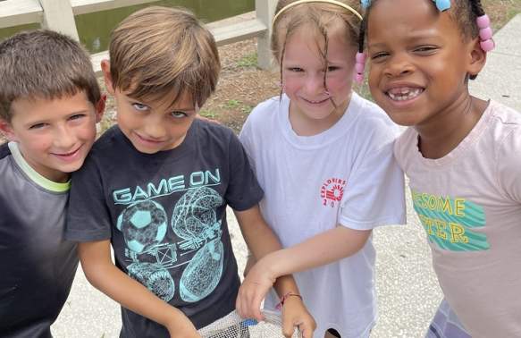 Children at camp using fishing net.